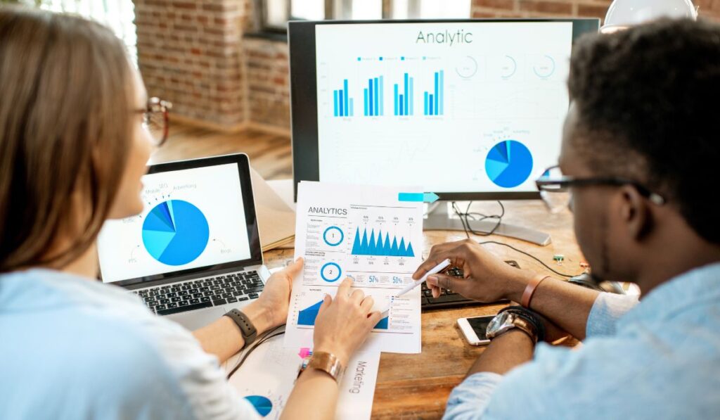 imagem de dois rapazes olhando para dados e analisando