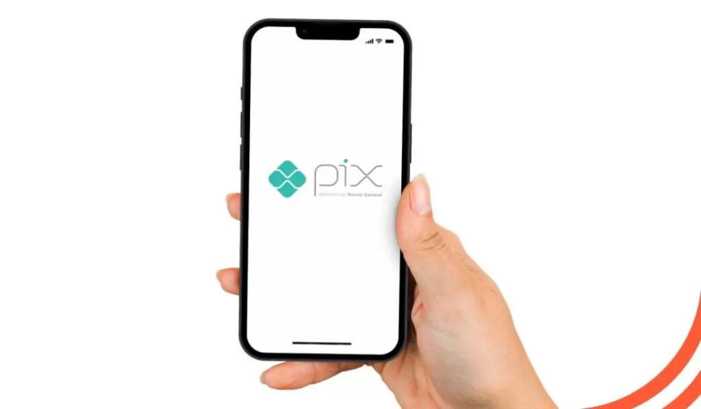imagem de uma mão segurando um celular com o nome pix na tela