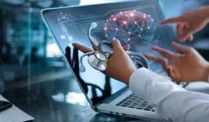 Tela de laptop com imagem de um cérebro com pontos interligados com mãos de uma médica gesticulando e segurando estetoscópio.