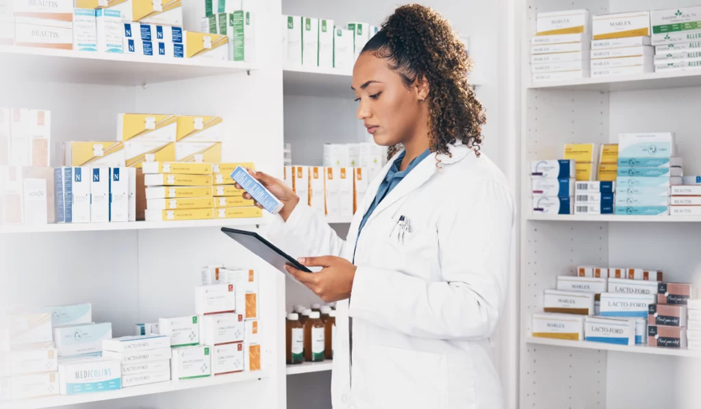 imagem de uma enfermeira vestida de jaleco  checando um remédio em uma farmácia ou laboratório