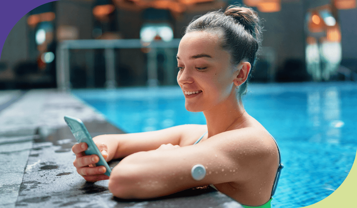 imagem de uma moça sorrindo olhando para um celular enquanto faz uma teleconsulta em uma piscina