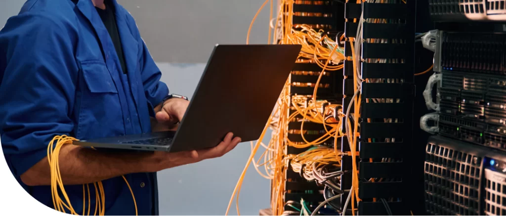 Profissional de TI com notebook nas mãos para ilustrar como implementar o outsourcing de TI de forma eficiente