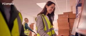 Profissional trabalhando no computador dentro do armazém para ilustrar o conceito de blockchain na logística