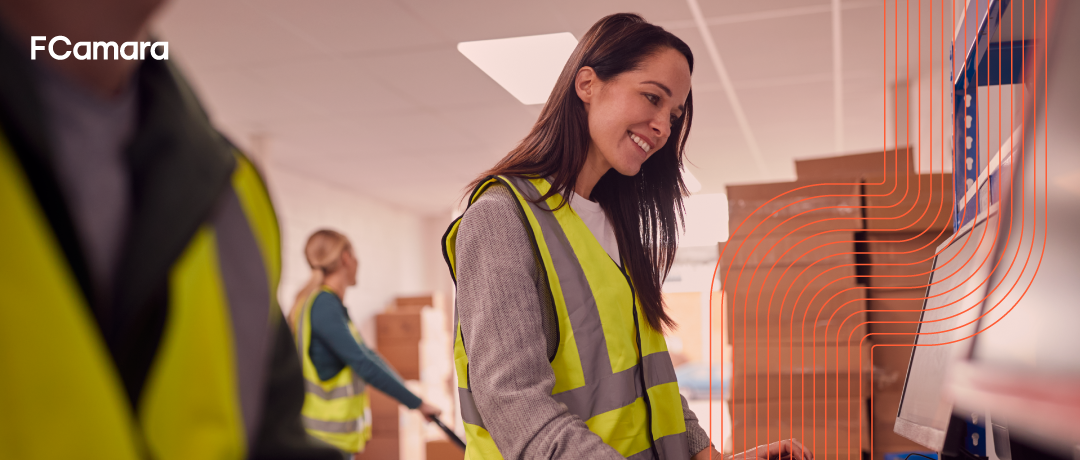 Profissional trabalhando no computador dentro do armazém para ilustrar o conceito de blockchain na logística