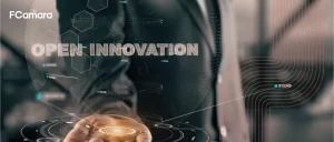 Foto de executivo com a palma da mão aberta e com o título "Open Innovation" para ilustrar tema inovação aberta