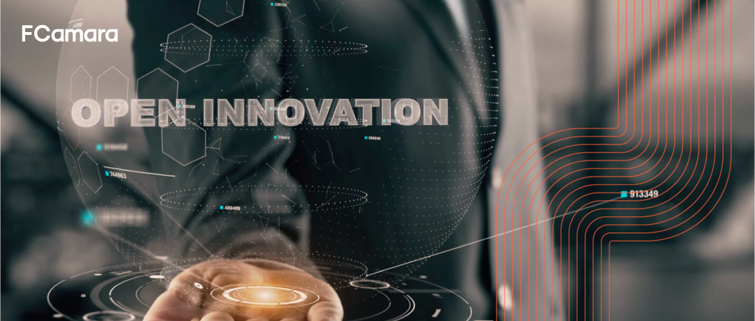 Foto de executivo com a palma da mão aberta e com o título "Open Innovation" para ilustrar tema inovação aberta