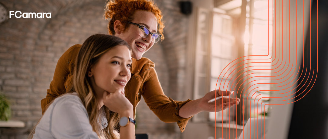 Dupla de profissionais analisando sorridentes no computador métricas de e commerce